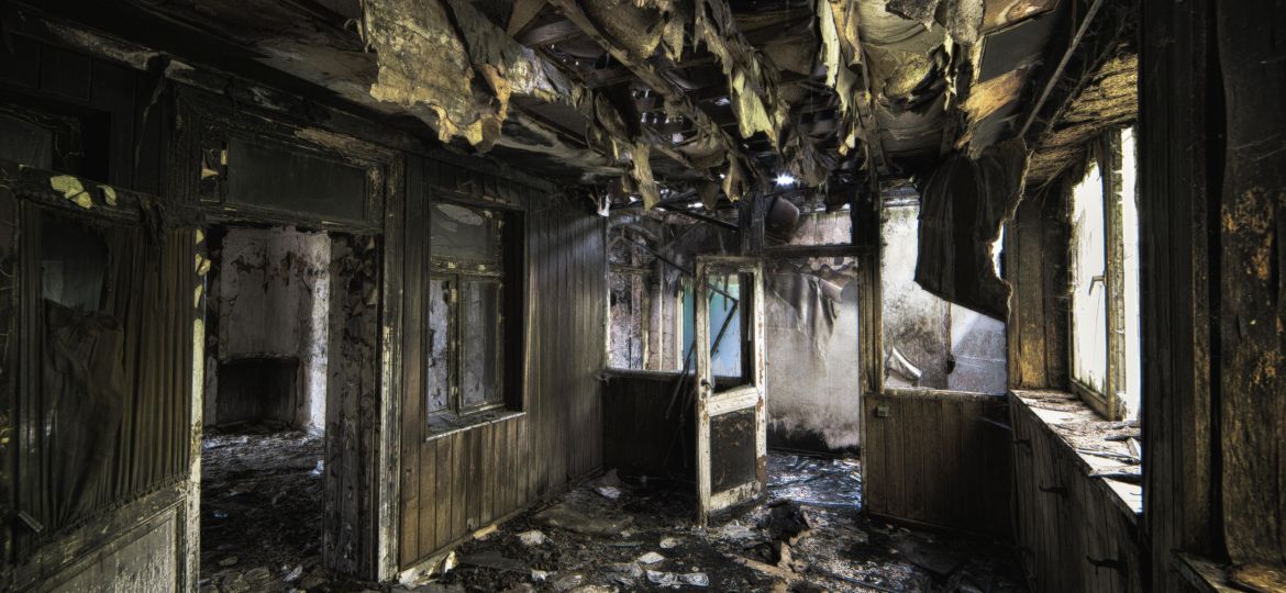 Inside shot of an abandoned destroyed building with burned walls and worn-out doors